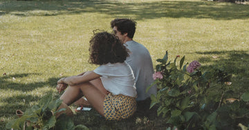 Woman standing barefoot on grass outdoors, illustrating the practice of grounding for better sleep and less inflammation
